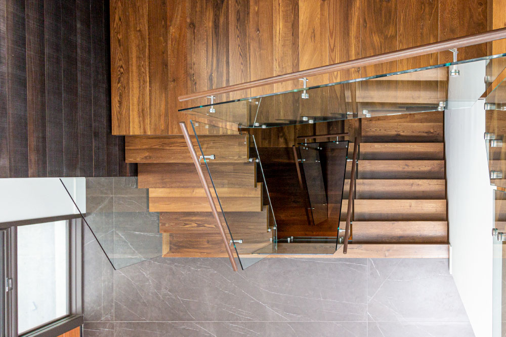 mono-stringer stair installation / metal step support / glass standoffs attached to metal step support / wood step liner